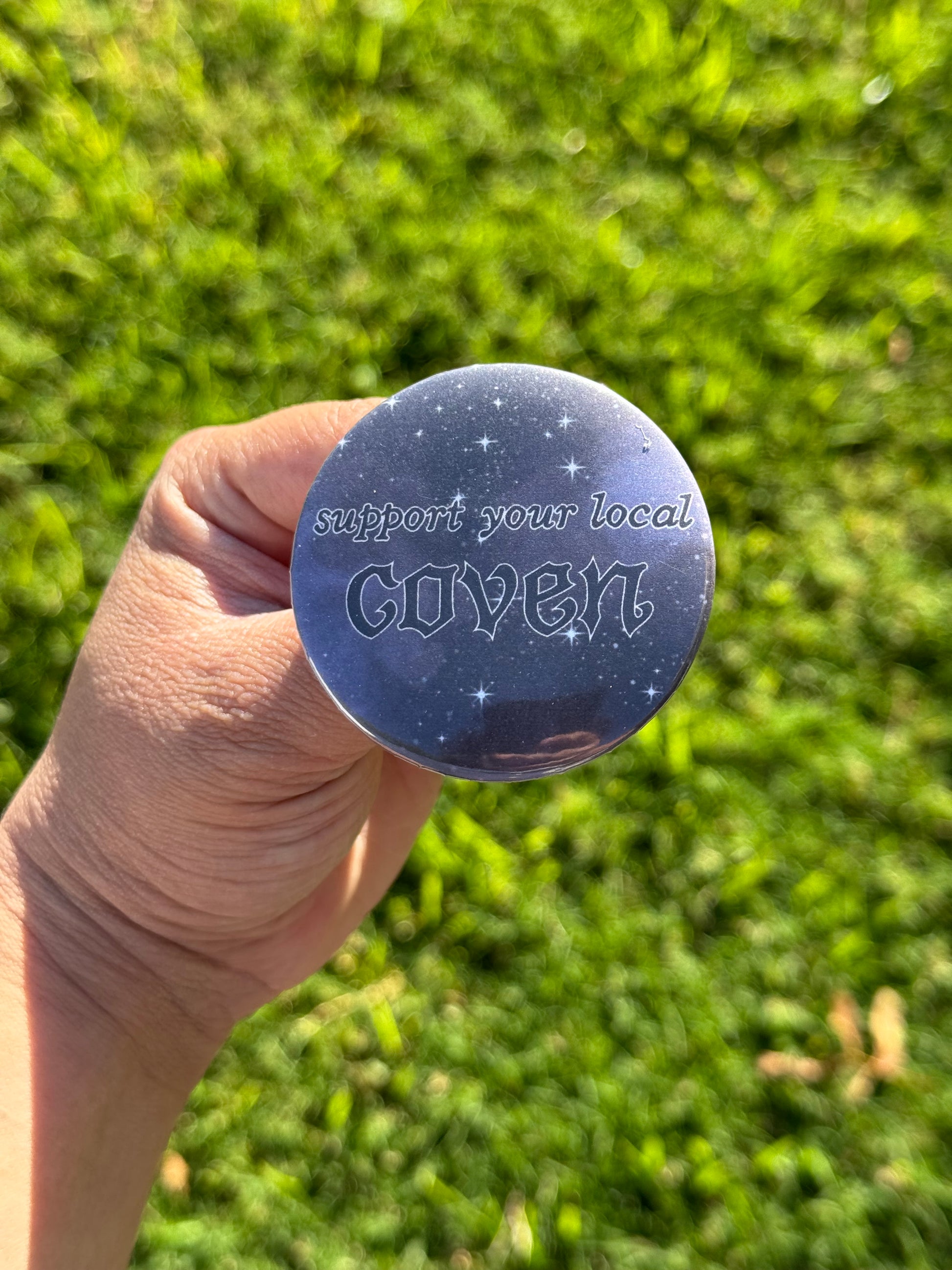 Button pin with starry background and text says “Support your local coven”